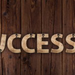 Brown Wood Canvas with Word Success Spread Across It